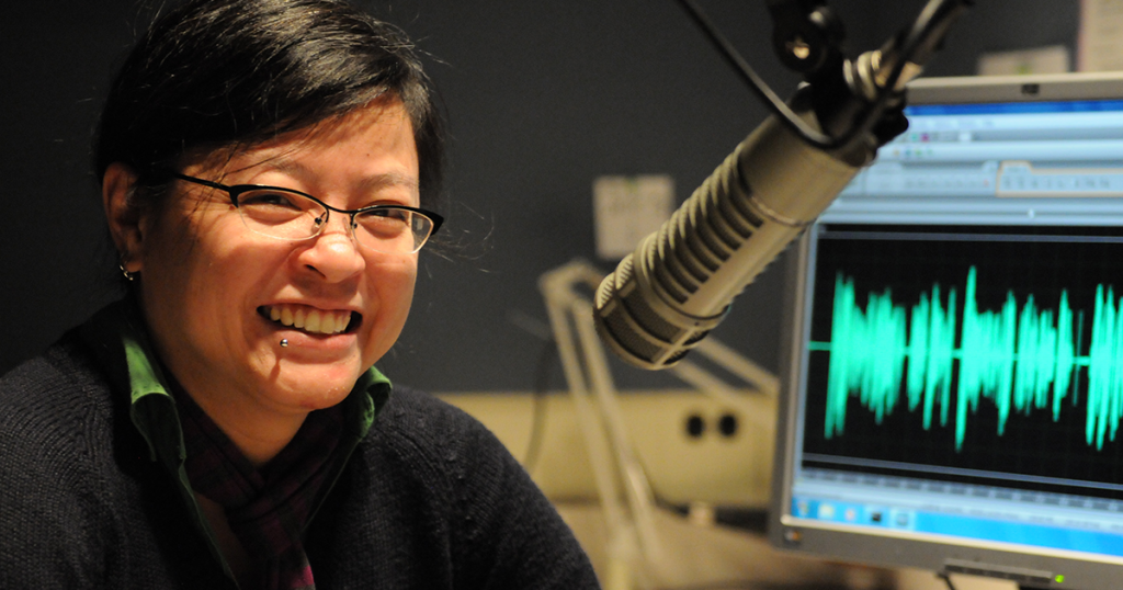 Eva Ngo sits in a recording booth at the Washington Talking Book and Braille Library