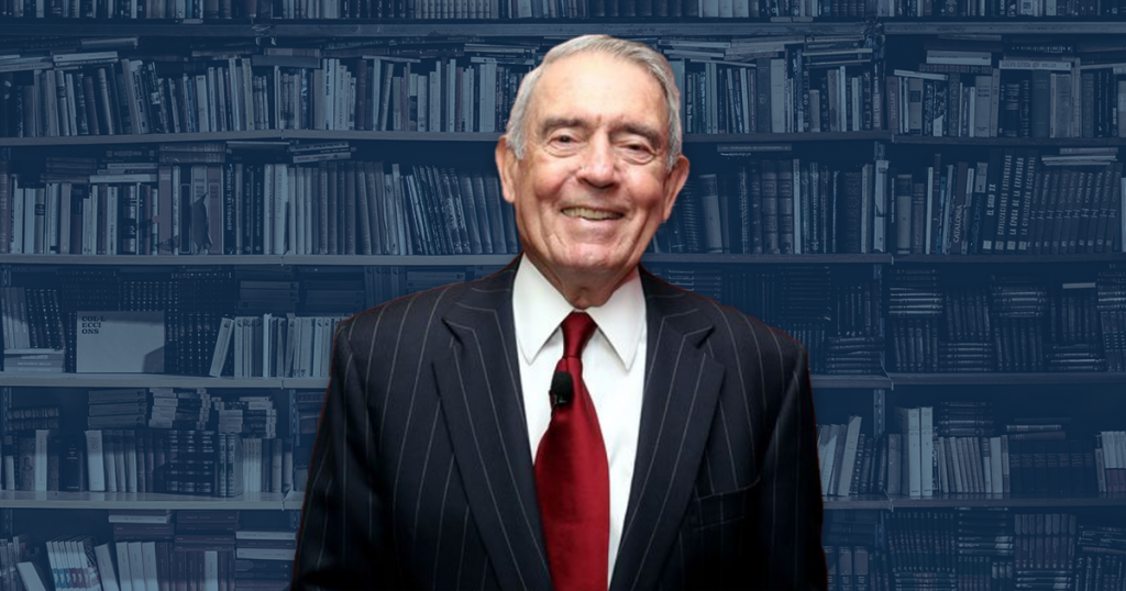 Dan Rather in front of library shelves