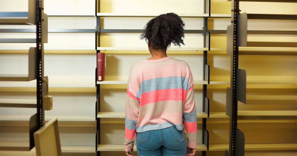 Teen looking at library shelves