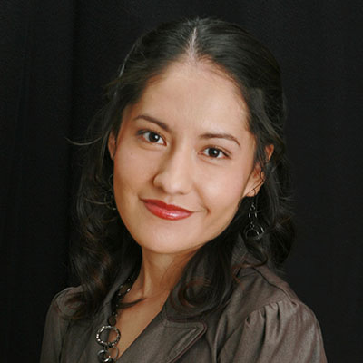 Photo of a woman with long ark hair and a dark gray shirt