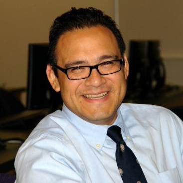 Photo of man wih short hair and glasses wearing a tie