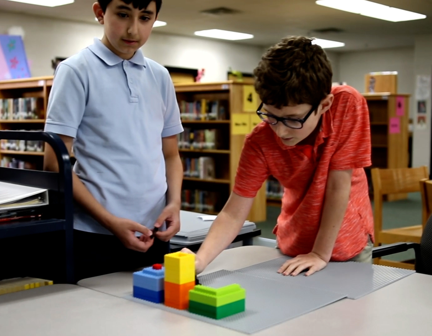 Two boys build with legos in the school library