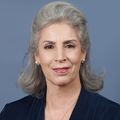 Photo of woman with gray hair in front of a blue background