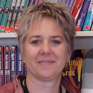 Photo of a woman with short hair in front of library shelves