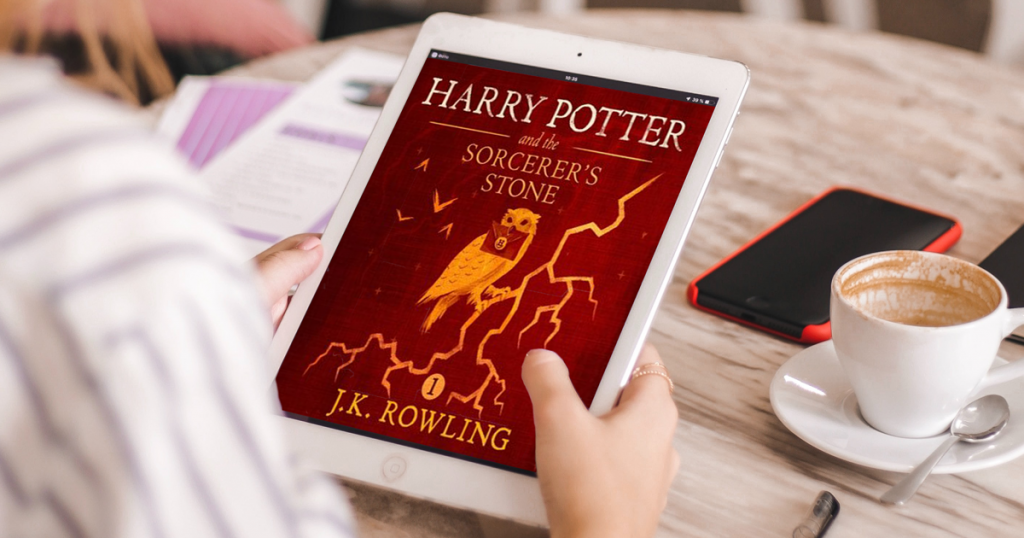 A person holding a tablet displaying the cover of Harry Potter and the Sorcerers Stone