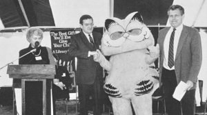 then-Secretary of Education William Bennett on stage with 1987-1988 ALA President Margaret Chisholm, then-NCLIS chairman Jerald Newman, and actor in Garfield costume at launch of Library Card Sign-up Month in 1987.