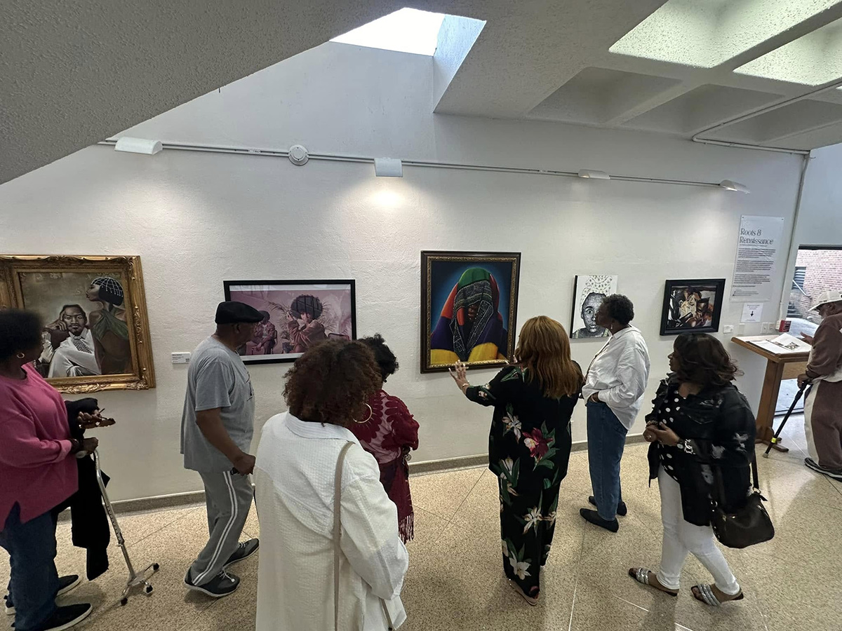 Photo of several people looking at a piece of art in an art exhibition.