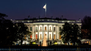 Photo of the White House at night.