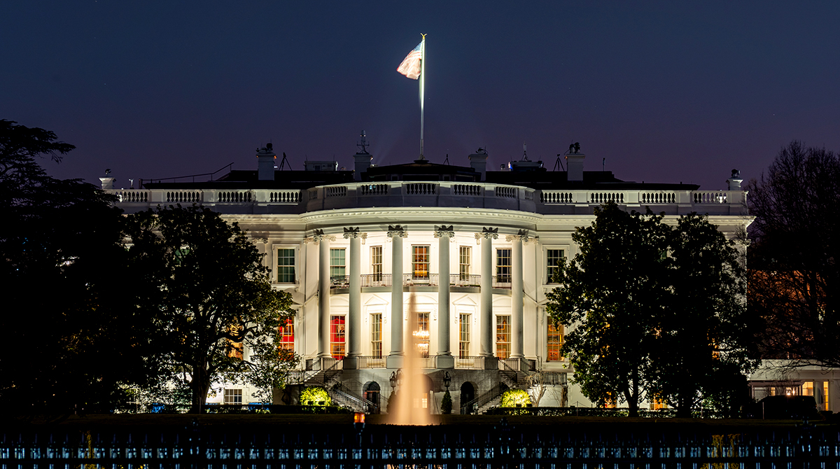 Photo of the White House at night.