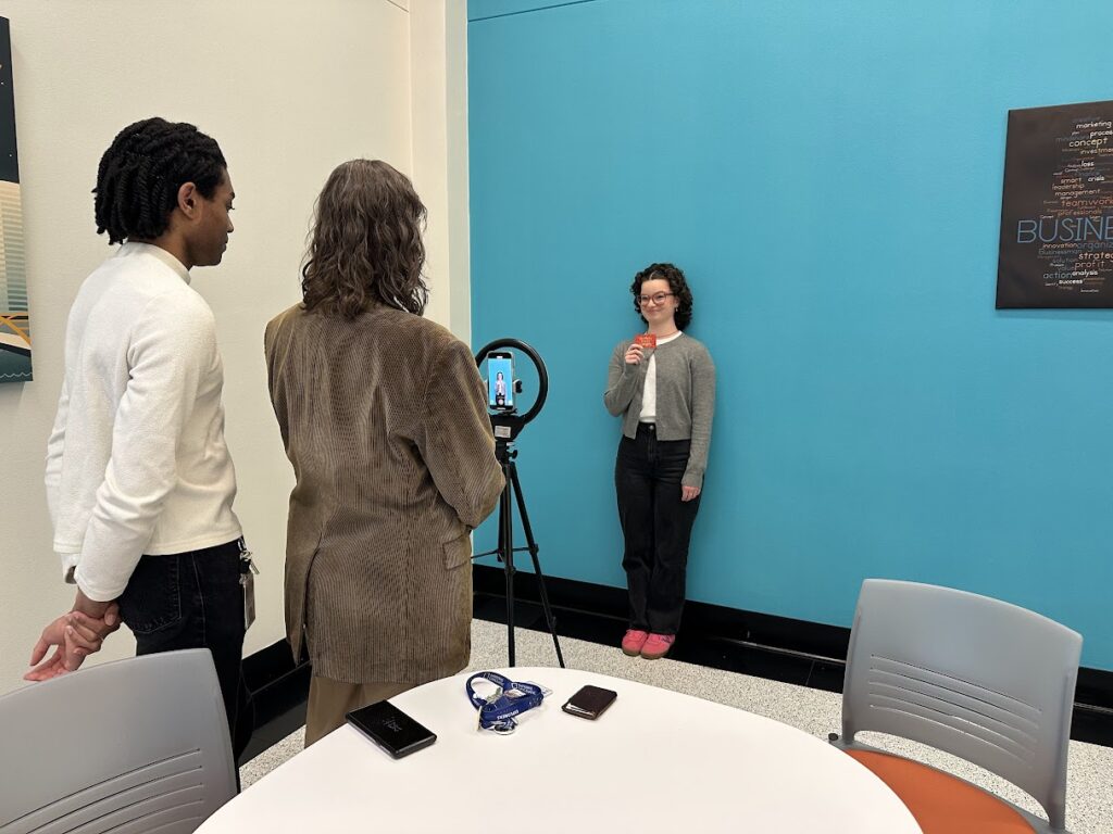 Filming against a bright teal background in the library's Business Commons