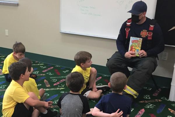 Chillicothe (Ill.) Community Fire Protection District Firefighter Tyler Millar reads "Arthur's Fire Drill" to a group of children at the Chillicothe Public Library.