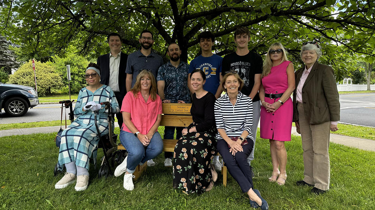 Photo of a group of people at a bench dedicated to the Dixie Giants baseball team