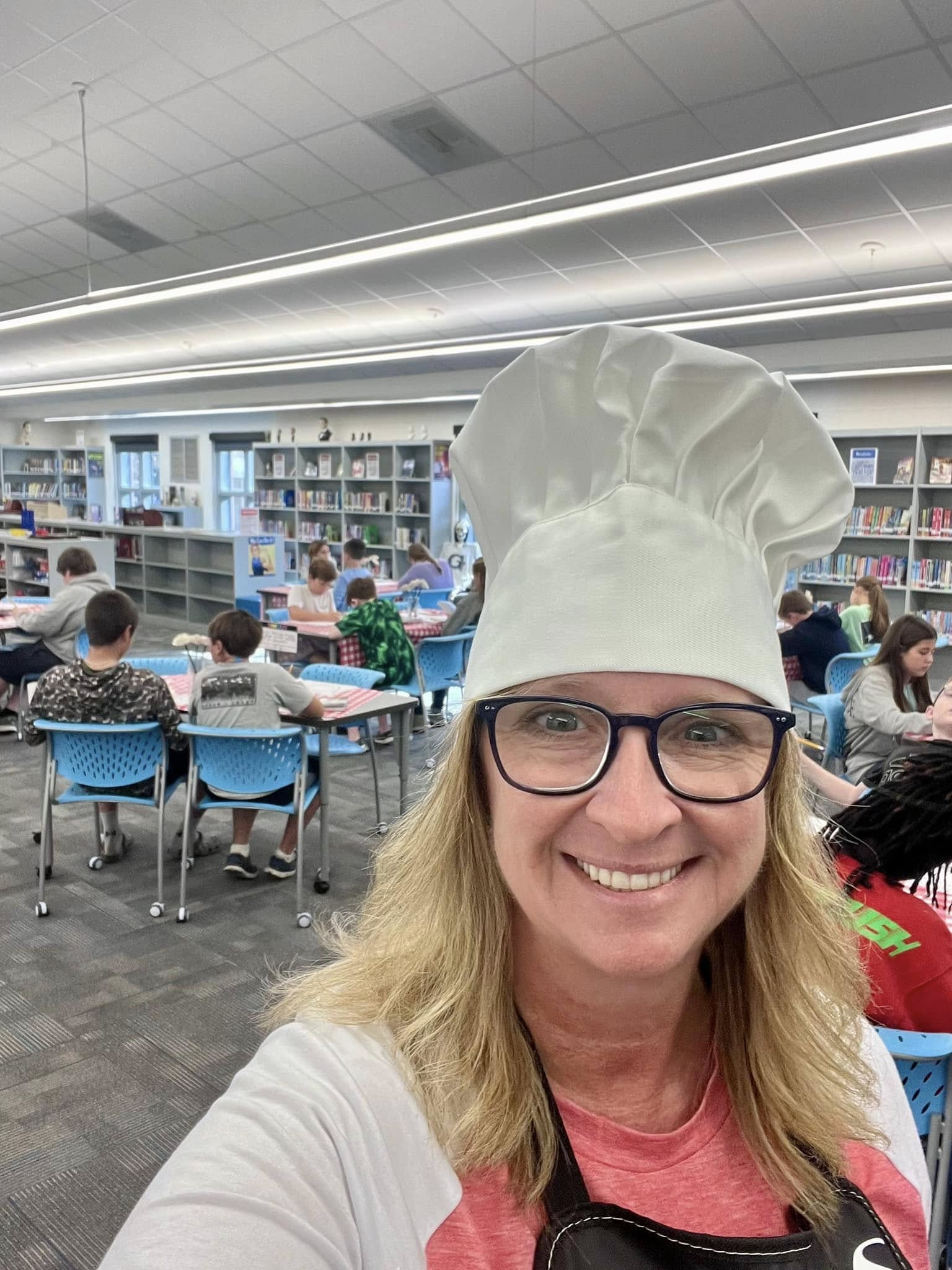 Selfie of librarian Jenny Cox wearing a chef's hat in her library