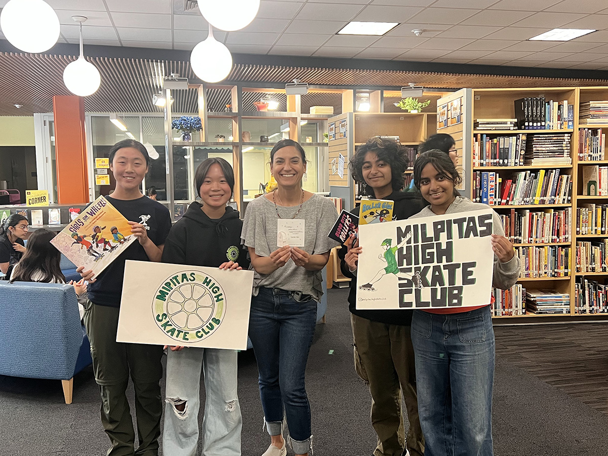 Librarian Mia Gittlen standing in the middle of a group of students from the Milpitas High Skate Club