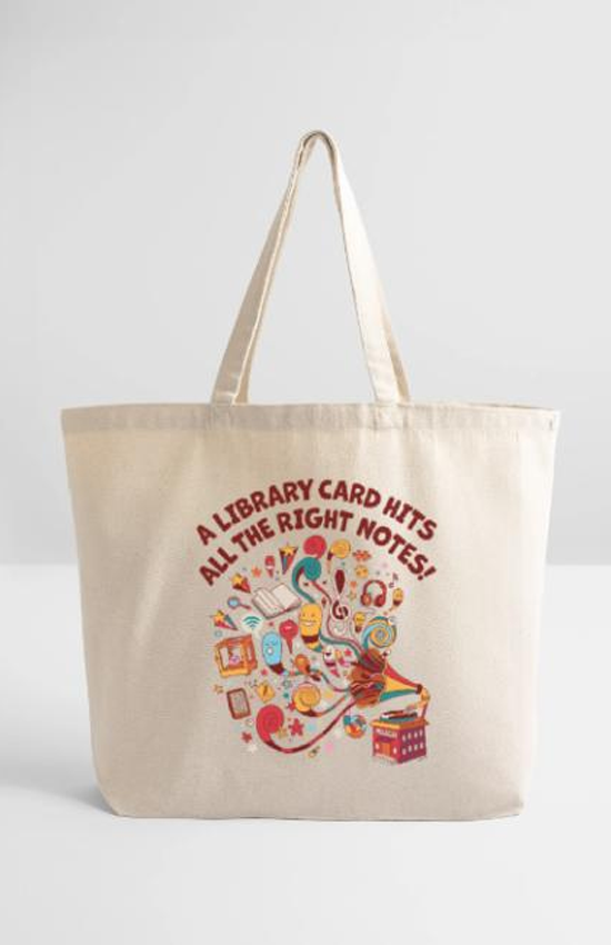 A tote bag with a bright and colorful design of a library as a gramophone and library services coming out of the speaker as joyful musical notes. Text reads "A library card hits all the right notes!"