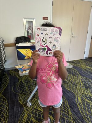 A student at White Center Library in Seattle shows off their Pokémon stickers at the library's Pokémon Club.